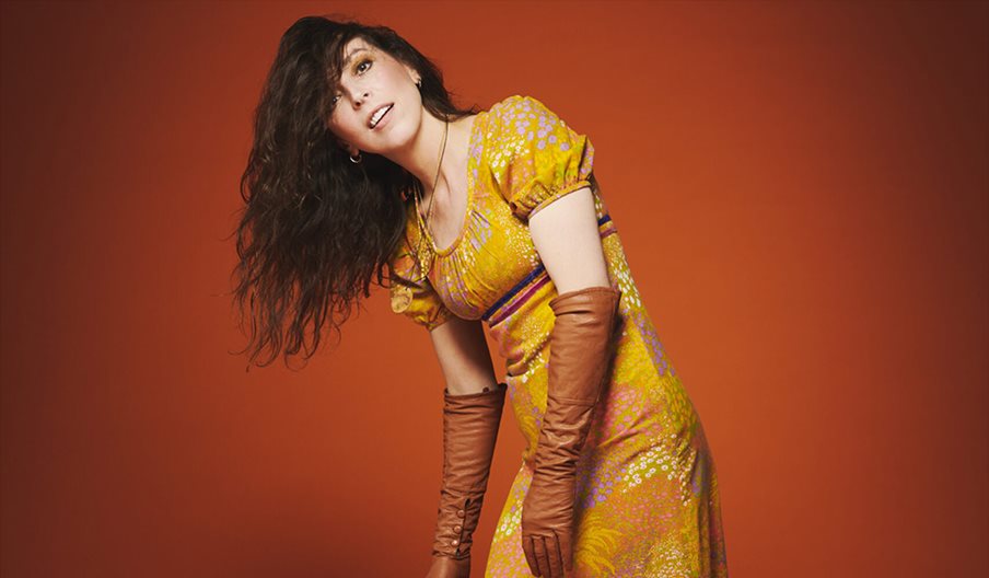 Bridget Christie in a gold dress for the promotional shot of her latest tour: Jacket Potato Pizza
