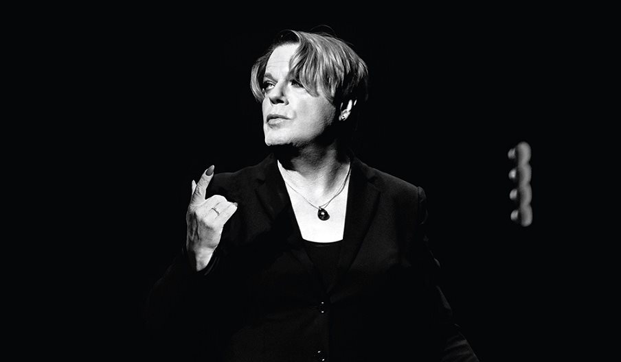 A black and white picture of Eddie Izzard on stage.