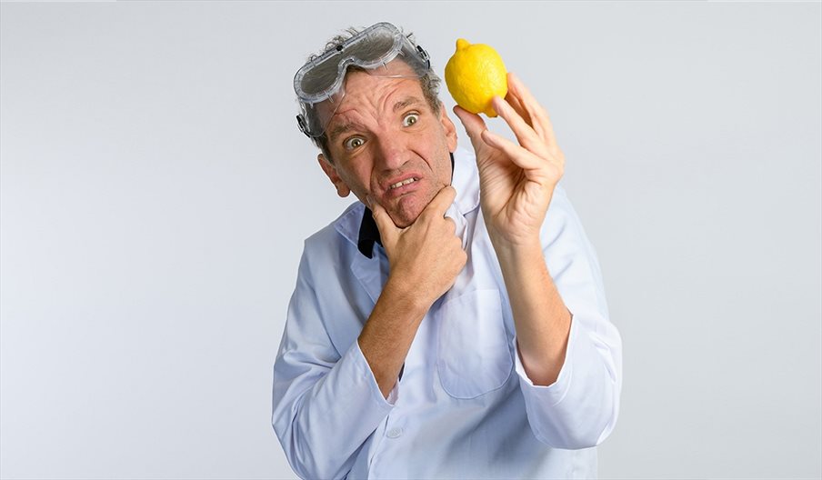Photograph of comedian Henning Wehn looking at a lemon