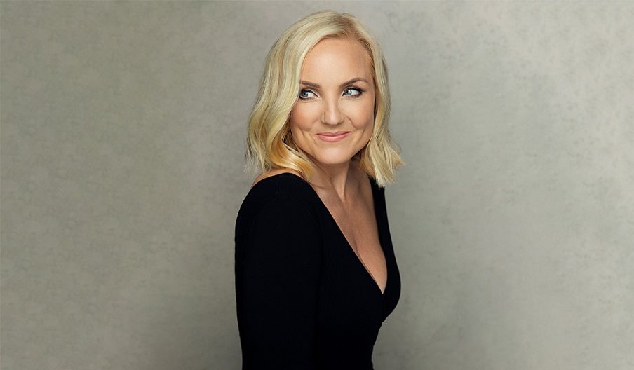 Photograph of Kerry Ellis for Queen of the West End, showing the singer in a black dress against a grey background