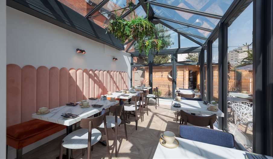 Dining tables set in the Glasshouse of The Garden Restaurant