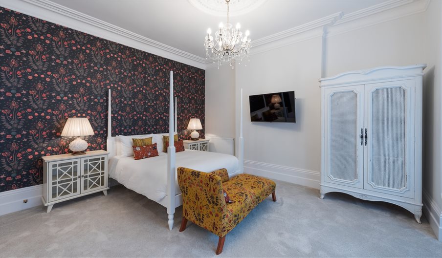 Modern four-poster bed in a room at The Clarence Boutique Rooms