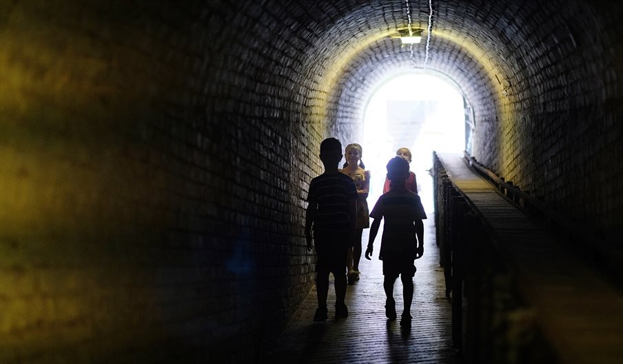 Children exploring a tunnel at Fort Nelson