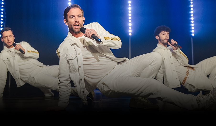 Three members of The Take That Experience performing a dance routine..