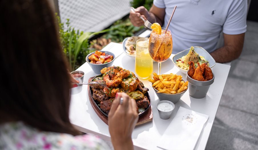 Two people enjoying al fresco food from Tap & Tandoor