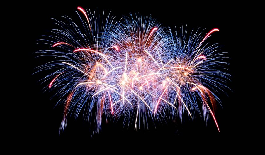 Stock photograph of fireworks going off against a black night sky