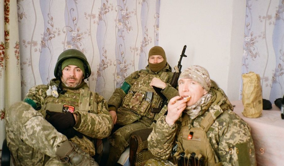 A photograph of three Ukrainian soldiers in military fatigues during downtime.
