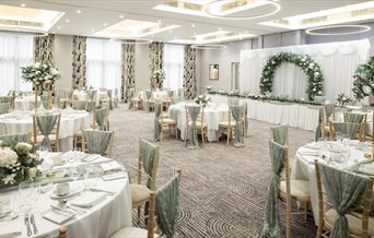 A function set up with tables and chairs for a wedding.