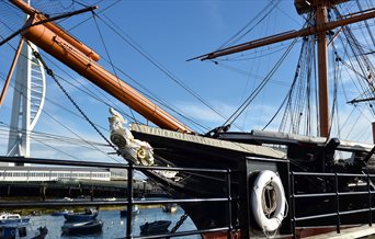 The exterior of HMS Warrior with the Spinnaker Tower in the distance