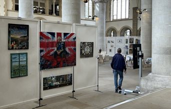 A man walking round an art exhibition at Portsmouth Cathedral.