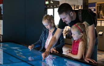 A family looks at an exhibit at the National Museum of the Royal Navy