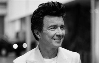 Black and white portrait photograph of Rick Astley