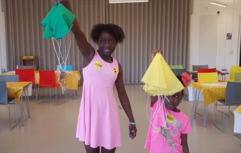 Two girls at The D-Day Story showing off the parachutes they've made