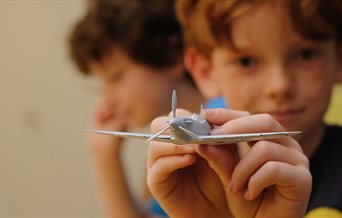 Boy at The D-Day Story showing off an Airfix model of an aeroplane - credit Matt Scott-Joynt