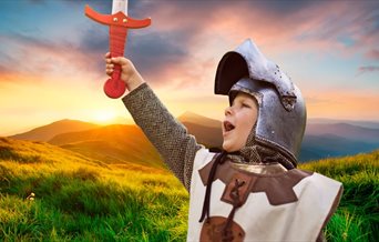 A child holding up a sword, for Medieval Mayhem at Fort Nelson