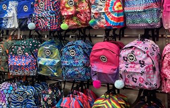 Colourful backpacks lined up on racks at the Hype outlet in Gunwharf Quays