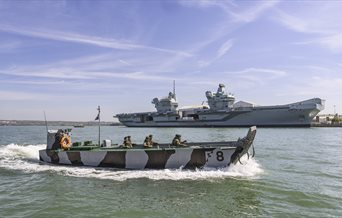 A Falklands F8 Landing Craft at sea, with a QE Class Aircraft Carrier behind