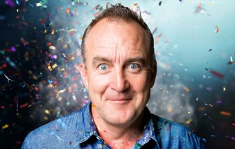 Head and shoulders shot of comedian Jimeoin with confetti around him.