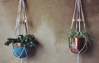 Photograph of two Macrame Pot Hangers on a wall