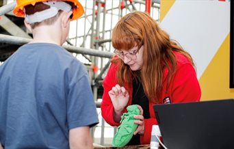 A woman showing a child one of the pests which could impact the ship.