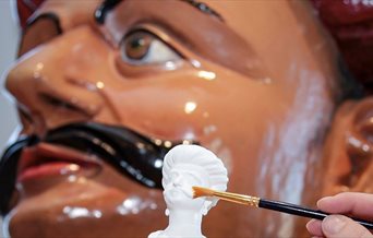 Photograph of a 3D printed miniature and the figurehead on which it was based.