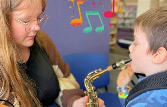 A young child learning an instrument with their teacher.