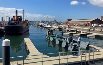 People on a boat at a Pontoon Open Day outside Boathouse 4