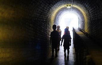 Children exploring a tunnel at Fort Nelson