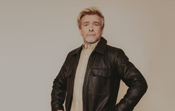 Photograph of Rhys Darby in a leather jacket