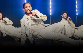 Three members of The Take That Experience performing a dance routine..