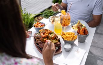 Two people enjoying al fresco food from Tap & Tandoor