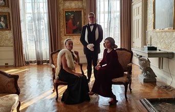 Three people in regency wear at Stansted House