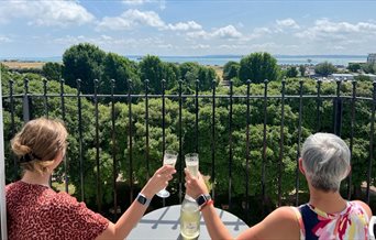 Two ladies toast the view from the balcony of Skyline Oasis