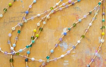 A number of beaded necklaces with different coloured beads.