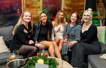 A group of five women enjoying the Winter Lodge at the Queens Hotel