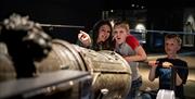 A family looking at the cannons on display at Portsmouth Historic Dockyard