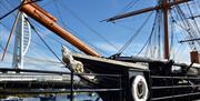 The exterior of HMS Warrior with the Spinnaker Tower in the distance