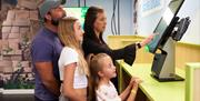 A family at one of the touch screens of Exploria in Portsmouth