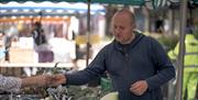 A farmer selling vegetables at a Hampshire Farmers' Market event