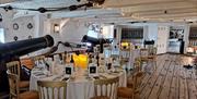 Round tables set for dinner at HMS Warrior