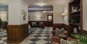 Seating area at the Queens Hotel with chairs and a chequerboard floor