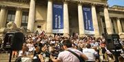 Music performance taking place for people on the steps outside Portsmouth Guildhall