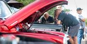 Classic car enthusiasts looking under the bonnet of a vehicle at Port Solent