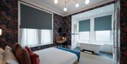 A modern room featuring a roll-top bath at The Clarence Boutique Rooms