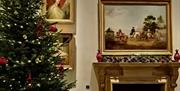 A view of a room at Stansted House with a Christmas Tree by the fireplace