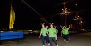 Participants in the Shining Stars Walk walking past HMS Warrior, with Spinnaker Tower in the background