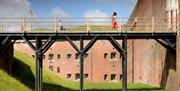 A young family walk across the bridge out of Fort Nelson