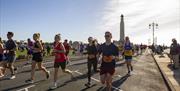 People taking part in the Great South Run, going past the War Memorial on Southsea Seafront