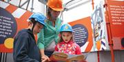 A family takes in the Victory Live experience at Portsmouth Historic Dockyard