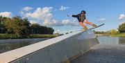 A wakeboarder performing tricks on the high speed wake line